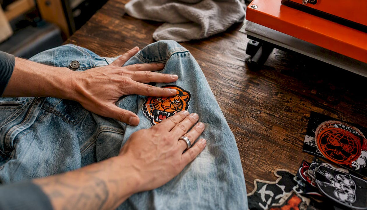 Hands heat pressing a custom patch on denim jacket